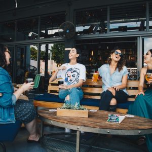 four-women-chatting-while-sitting-on-bench-1267697