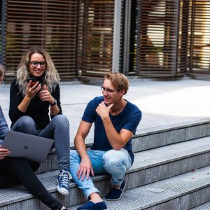 three-persons-sitting-on-the-stairs-talking-with-each-other-1438072